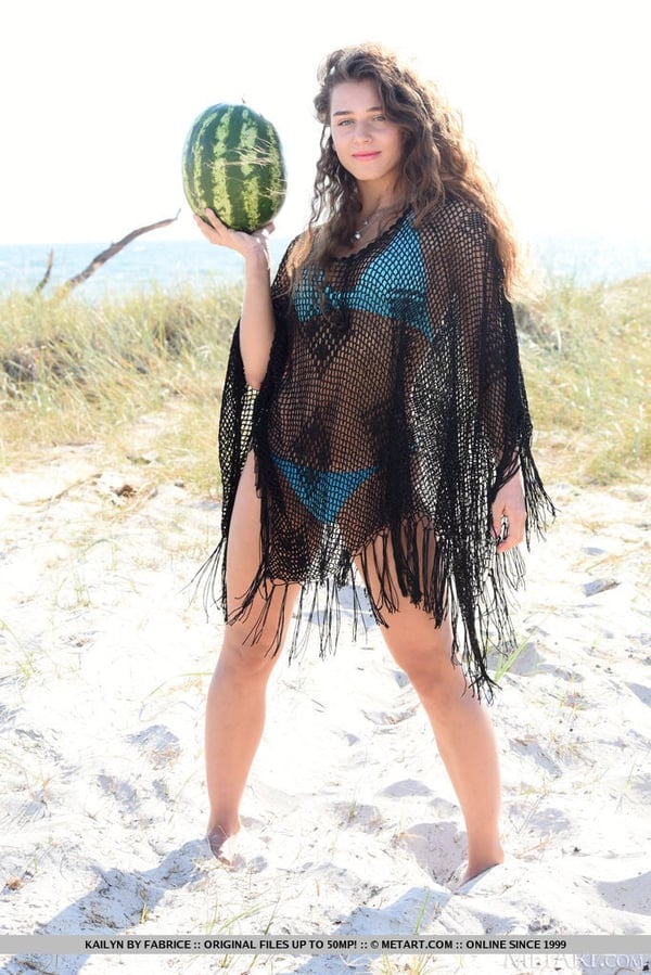 Young solo girl Kailyn cracks open a watermelon while getting naked on a beach