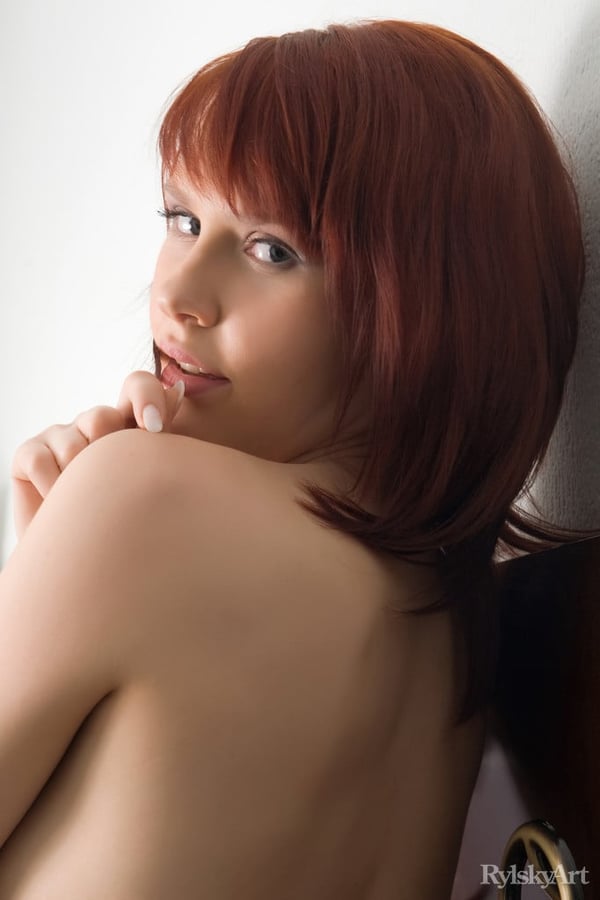 Picture by glambabes-galleries showing 'Pale redhead Anelie casts sultry looks while getting naked on a window sill' number 4