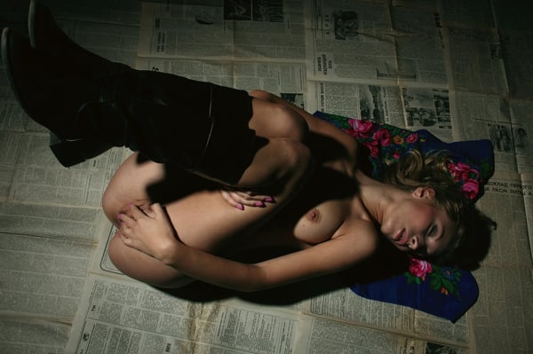 Picture by glambabes-galleries showing 'Blonde Daisy A masturbates lying on the newspapers in the dark room' number 5