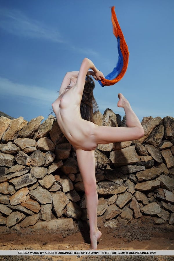 Naked teen Serena Wood strikes great solo poses by a dry stacked stone wall