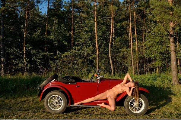 Picture by glambabes-galleries showing 'White solo girl poses naked in and on a vintage roadster out among the trees' number 8