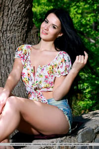 Dark haired teen Lola Marron undresses to pose nude on a stone wall