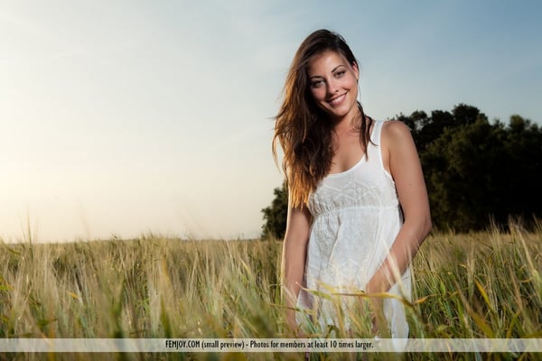Thin brunette model Lorena G pulls off a cotton dress for nude poses in grass