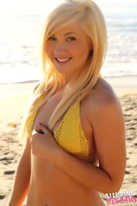 Natural blonde teen Ashlee Madison kneels on the beach in her new bikini