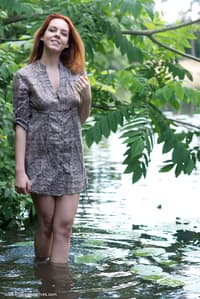 Pale redhead Candy Red slips off a dress to go naked in and out of a stream