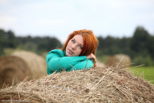 Picture by glambabes-galleries showing 'Natural redhead Amber A poses her naked teen body on round bale of hay' number 1