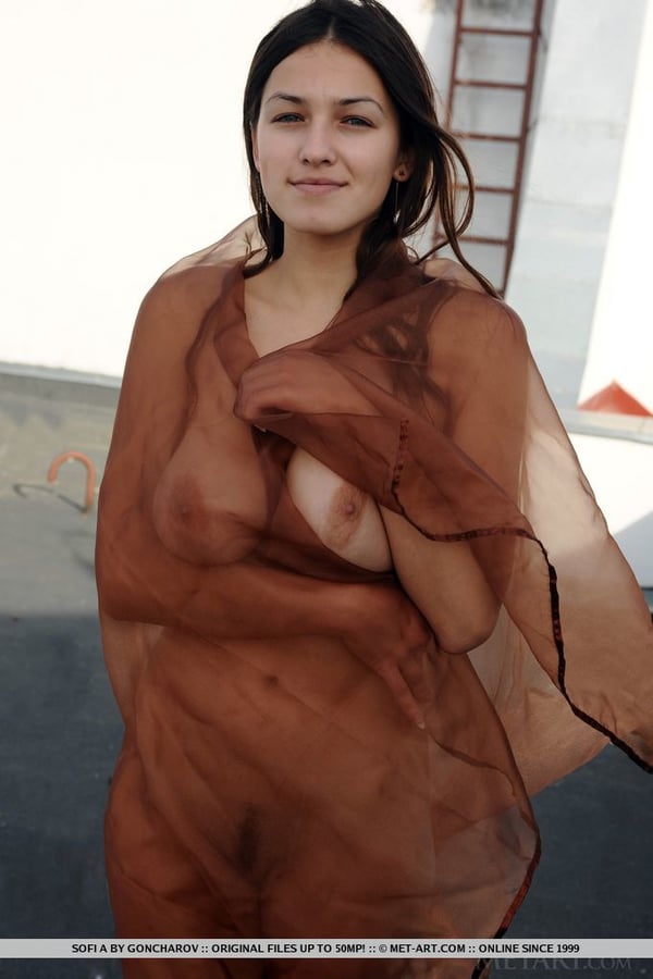 Picture by glambabes-galleries showing 'Busty teen Sofi A frees her naked body from a sheer wrap while on a rooftop' number 13